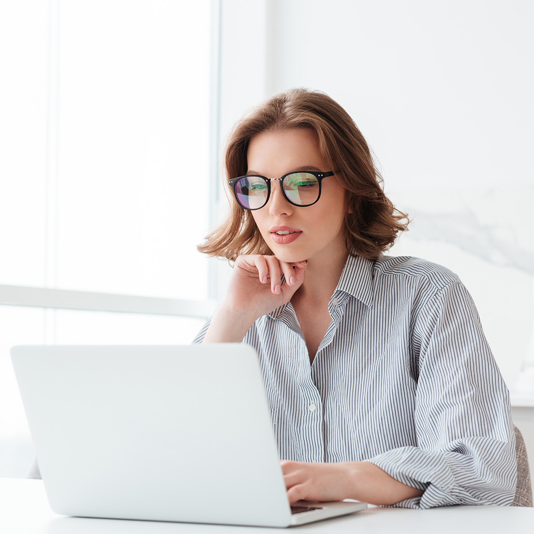 Una ragazza con occhiali che guarda il computer