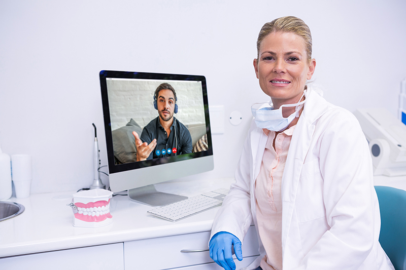 Dentista che effettua una televisita odontoiatrica ad un paziente